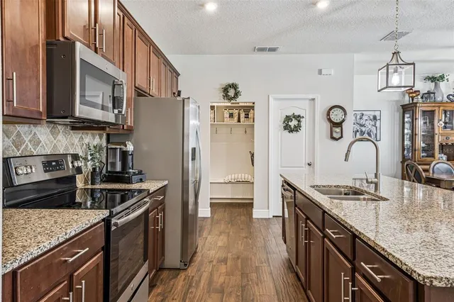a kitchen with stainless steel appliances granite countertop a stove and a refrigerator