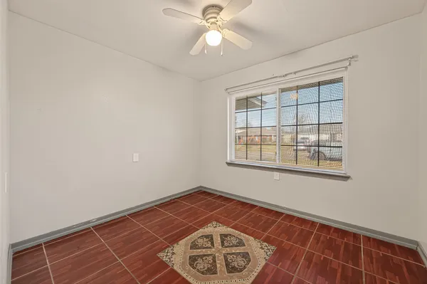 an empty room with fan and windows