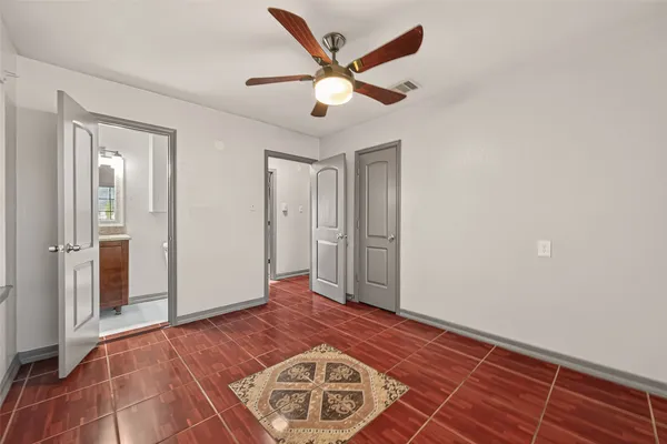 an empty room with wooden floor and ceiling fan