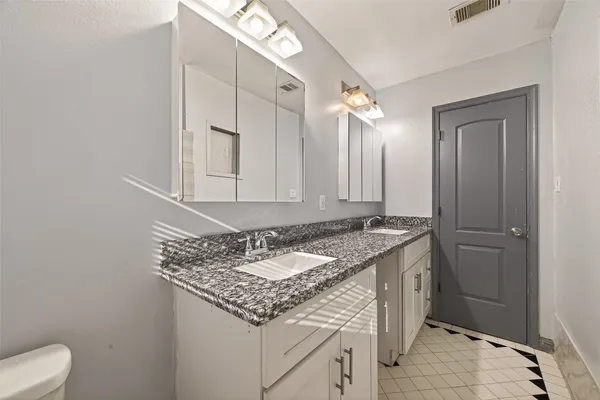 a bathroom with a granite countertop sink and a mirror
