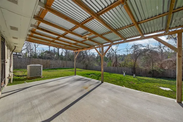 a view of a backyard with table and chairs under an umbrella