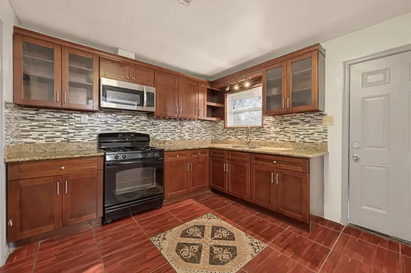 a kitchen with stainless steel appliances granite countertop a stove and cabinets