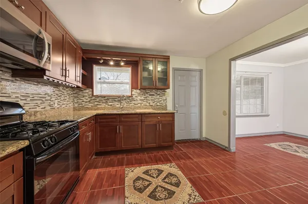 a kitchen with stainless steel appliances granite countertop a stove a sink and a microwave