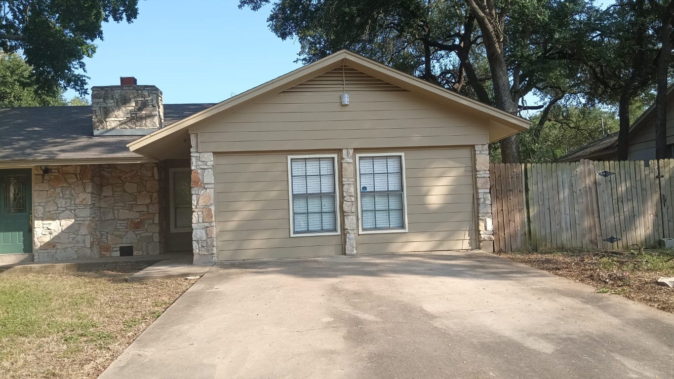 9405 Newberry Drive, Unit A Austin, TX 78729 - Photo 2 of 10 a front view of a house with a yard and garage