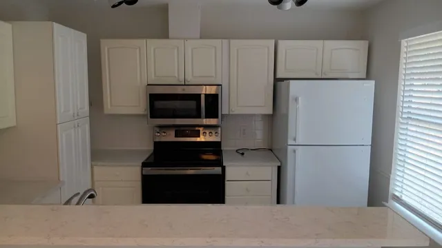 a kitchen with a refrigerator and a stove