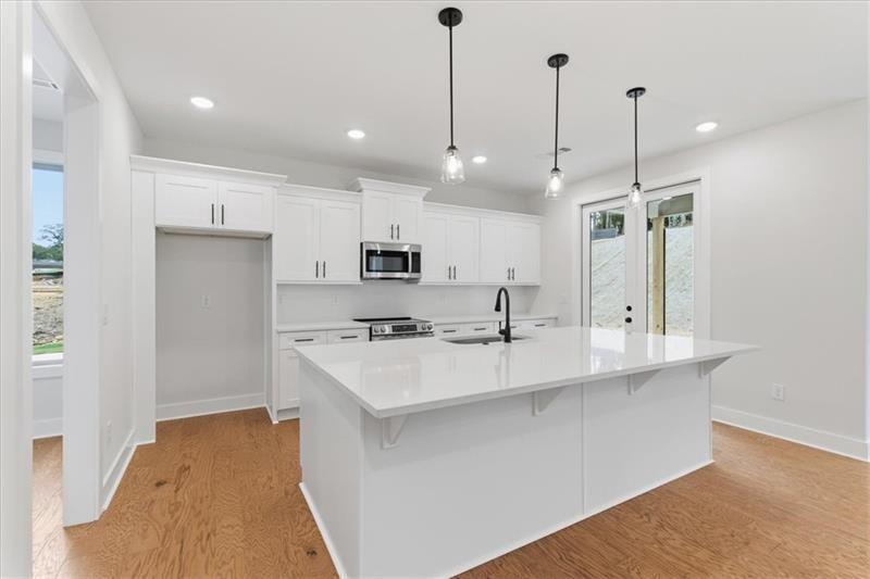 9 Everwood Court Rome, GA 30161 - Photo 11 of 44 a large kitchen with kitchen island a sink a center island and stainless steel appliances
