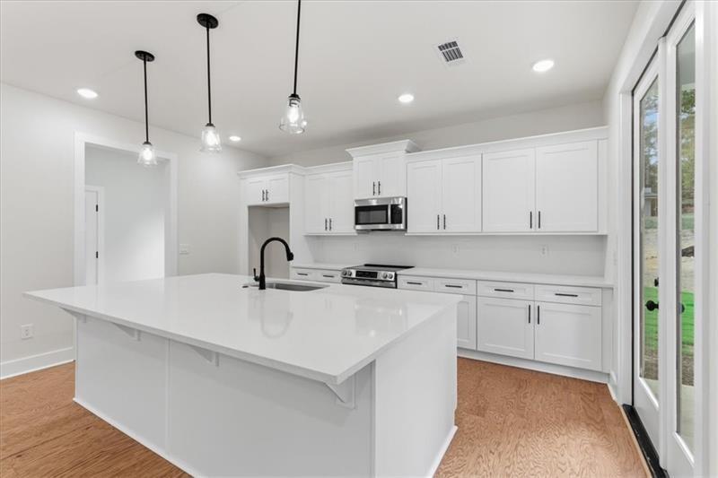 9 Everwood Court Rome, GA 30161 - Photo 12 of 44 a kitchen with stainless steel appliances granite countertop a sink a stove a refrigerator and white cabinets with wooden floor