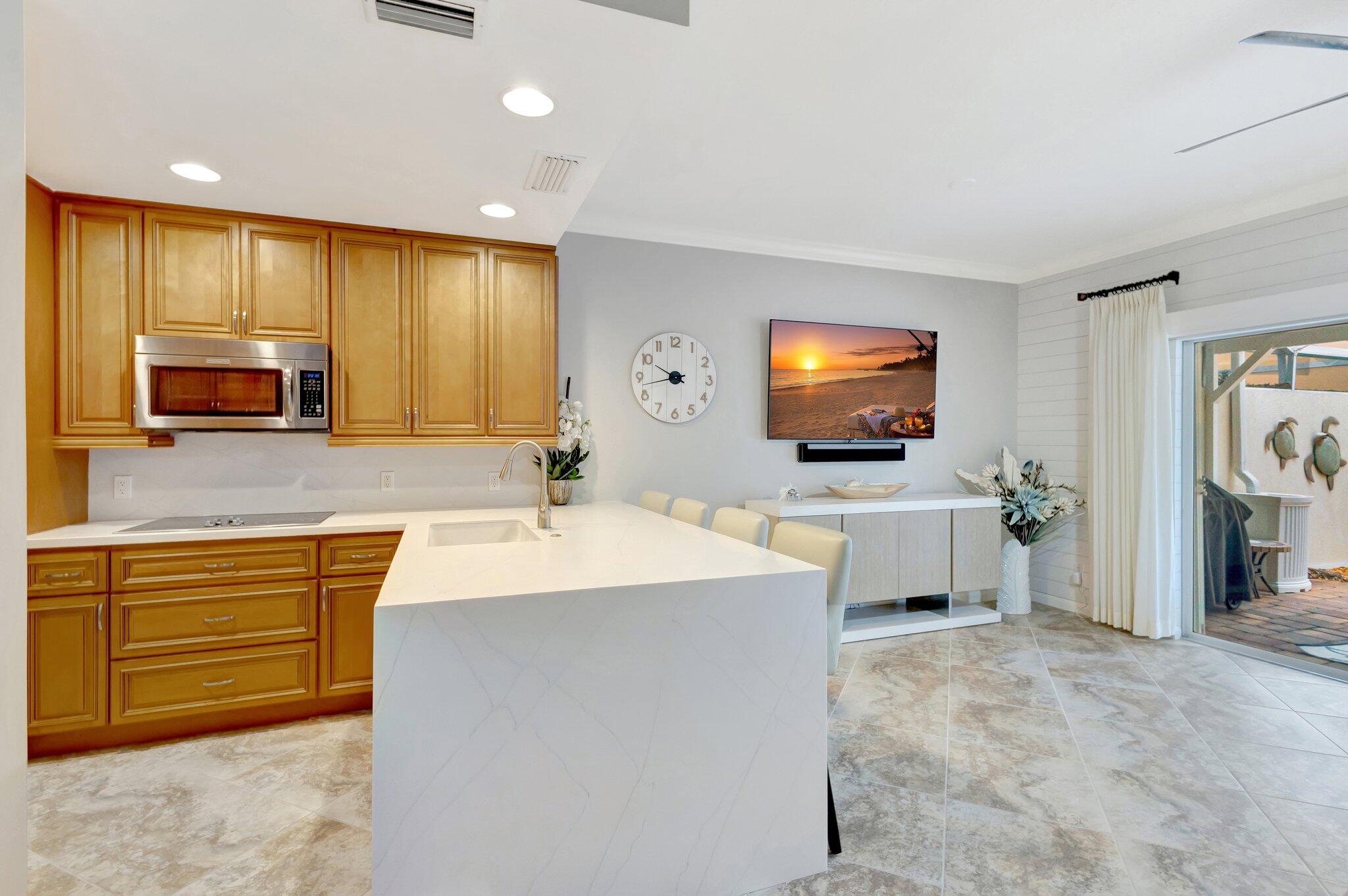 39 Laurel Oaks Circle Tequesta, FL 33469 - Photo 4 of 47 a large kitchen with stainless steel appliances a stove a sink a microwave and a refrigerator