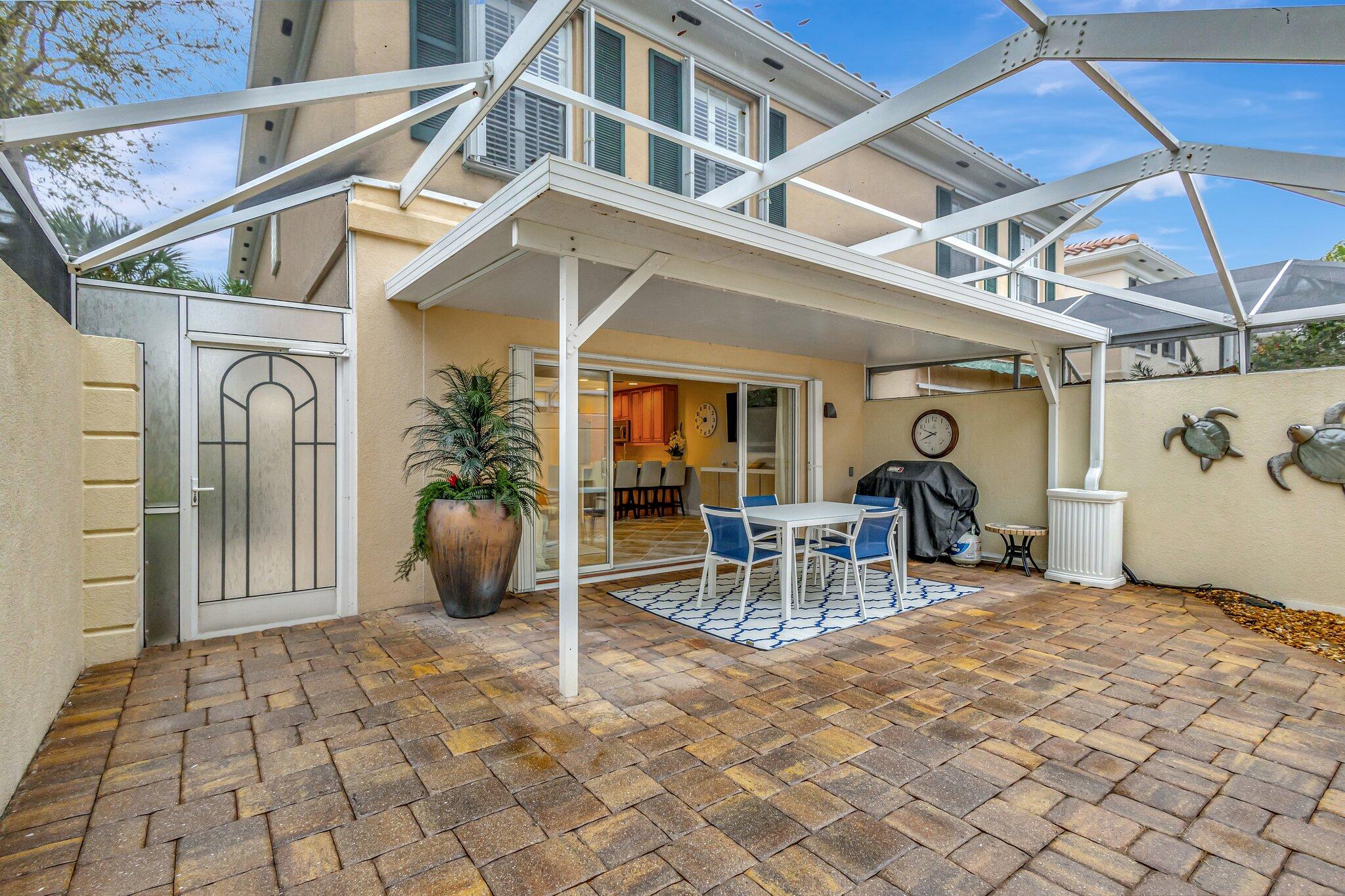 39 Laurel Oaks Circle Tequesta, FL 33469 - Photo 45 of 47 a view of a patio with a table and chairs and potted plants