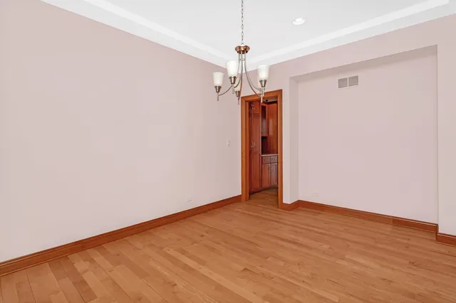 a view of a hallway with wooden floor and a window
