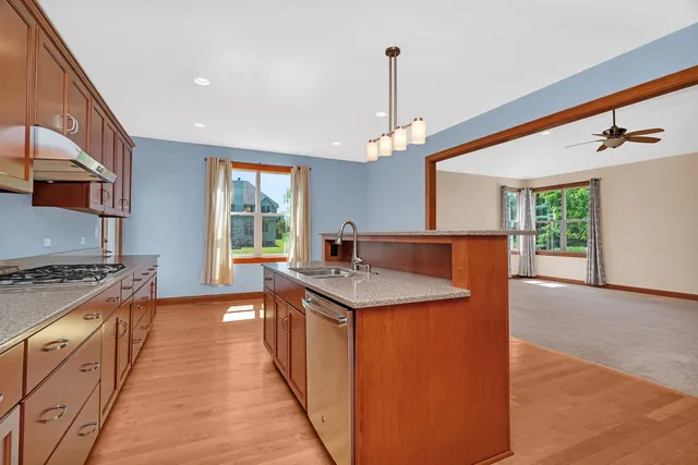 a kitchen with stainless steel appliances granite countertop a stove and a sink