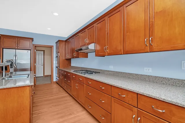 a kitchen with stainless steel appliances granite countertop a sink stove and cabinets