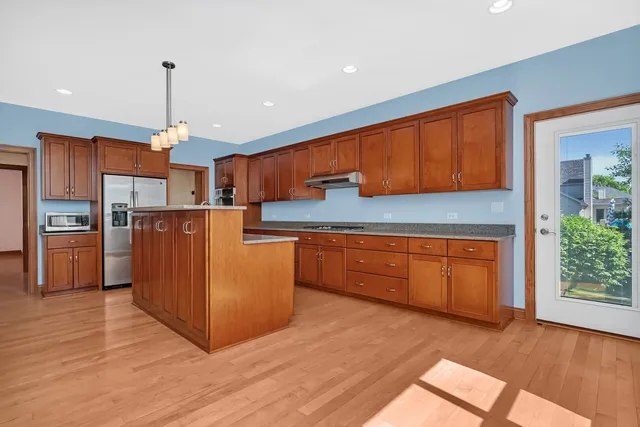 a kitchen with wooden floors and wooden cabinets