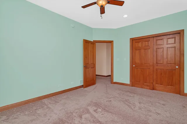 an empty room with chandelier fan