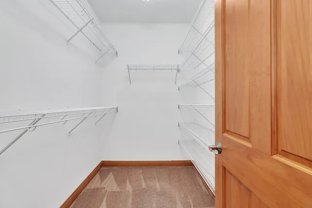 a view of walk in closet with empty racks