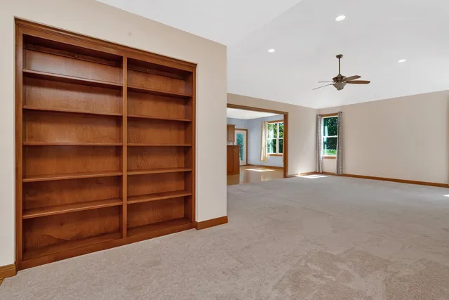 a view of an empty room with a fireplace and a window