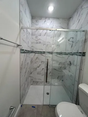 a bathroom with a toilet and a shower