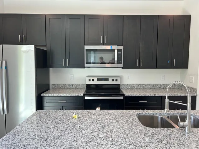 a kitchen with a stove a microwave and refrigerator