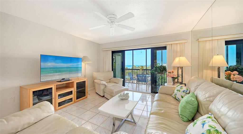 6234 Midnight Pass Road, Unit 307 Sarasota, FL 34242 - Photo 14 of 61 a living room with furniture and a flat screen tv