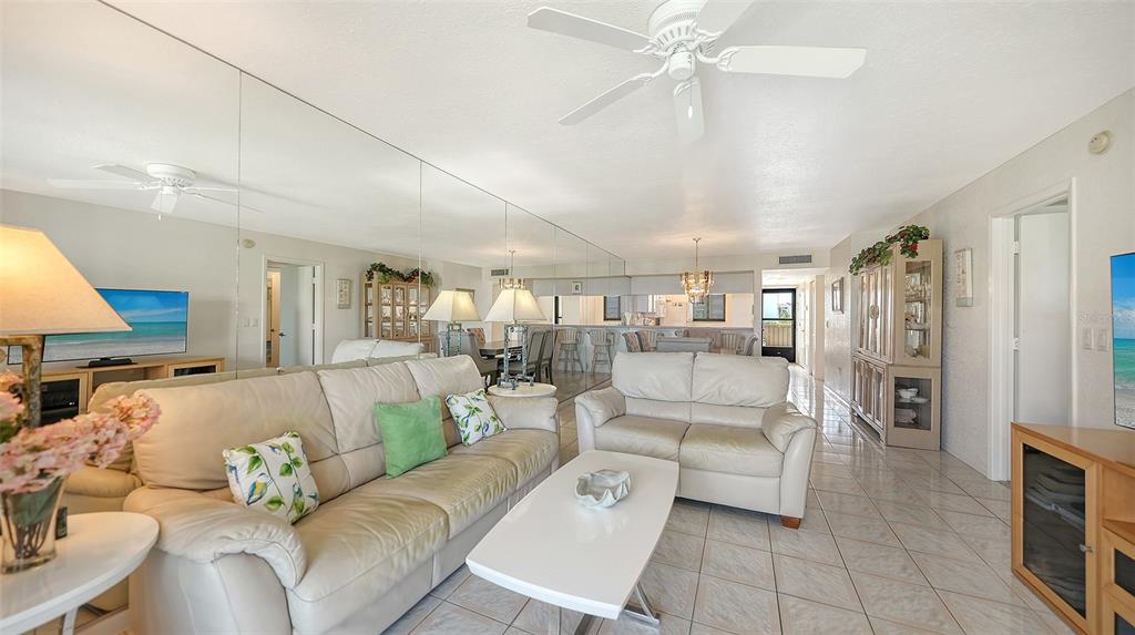 6234 Midnight Pass Road, Unit 307 Sarasota, FL 34242 - Photo 20 of 61 a living room with furniture white walls and chandelier