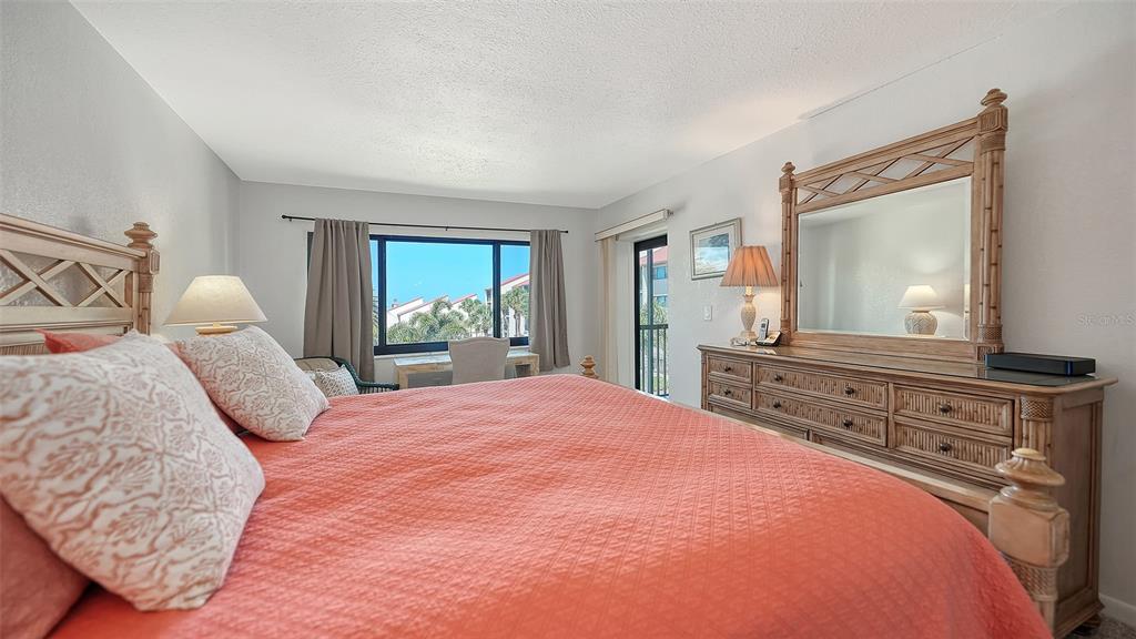 6234 Midnight Pass Road, Unit 307 Sarasota, FL 34242 - Photo 23 of 61 a bedroom with a large bed and a dresser