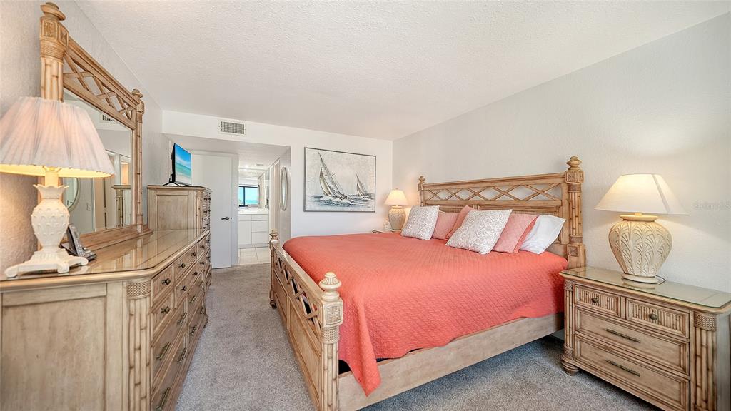 6234 Midnight Pass Road, Unit 307 Sarasota, FL 34242 - Photo 26 of 61 a bedroom with a bed a mirror on dresser and a window