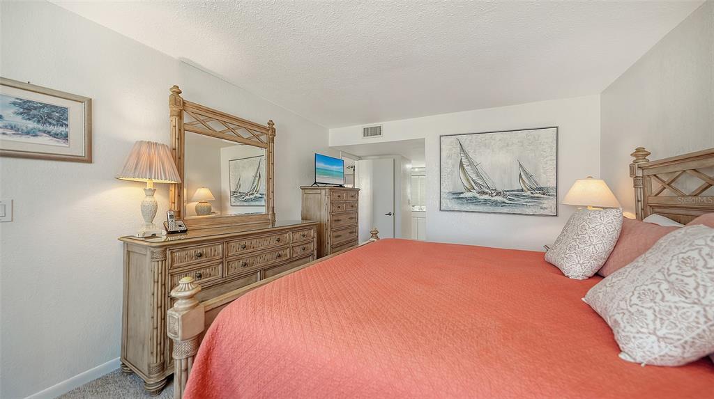 6234 Midnight Pass Road, Unit 307 Sarasota, FL 34242 - Photo 27 of 61 a bedroom with a large bed and a dresser