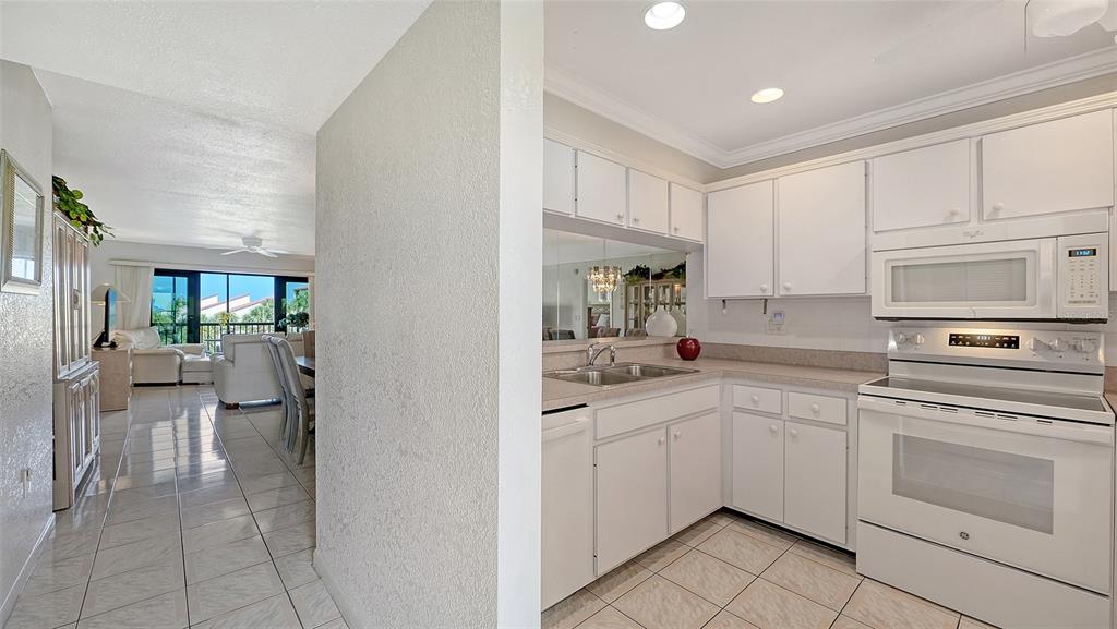 6234 Midnight Pass Road, Unit 307 Sarasota, FL 34242 - Photo 3 of 61 a kitchen with white cabinets and white appliances