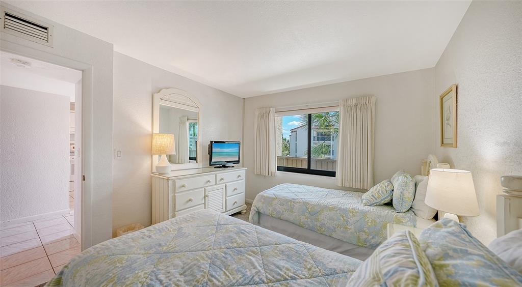 6234 Midnight Pass Road, Unit 307 Sarasota, FL 34242 - Photo 34 of 61 a bedroom with a bed and a couch