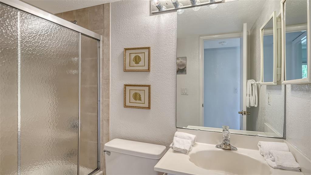 6234 Midnight Pass Road, Unit 307 Sarasota, FL 34242 - Photo 36 of 61 a bathroom with a sink toilet and shower