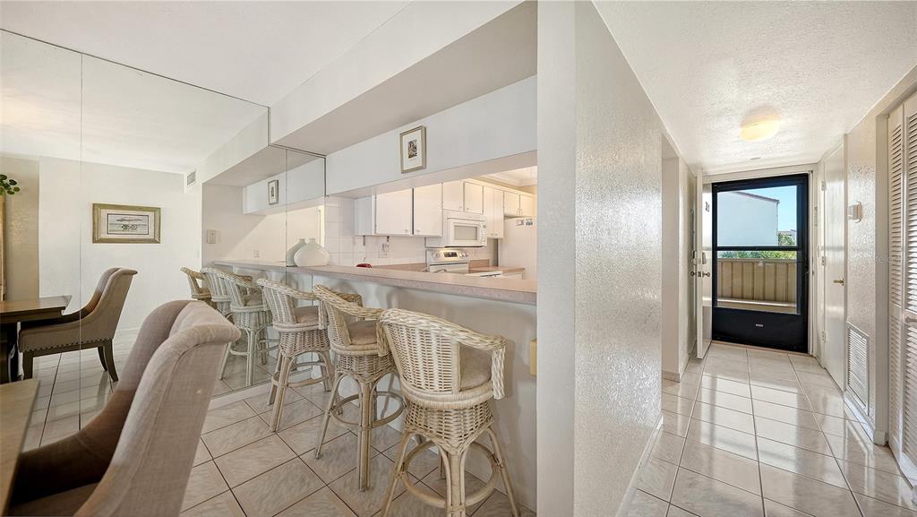 6234 Midnight Pass Road, Unit 307 Sarasota, FL 34242 - Photo 5 of 61 a kitchen with stainless steel appliances a table and chairs