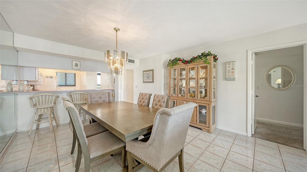 6234 Midnight Pass Road, Unit 307 Sarasota, FL 34242 - Photo 10 of 61 a view of a dining room with furniture and chandelier
