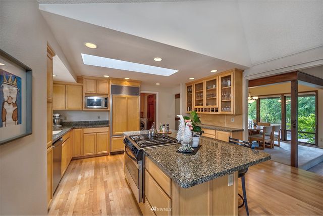 a kitchen with stainless steel appliances granite countertop sink stove and wooden floor