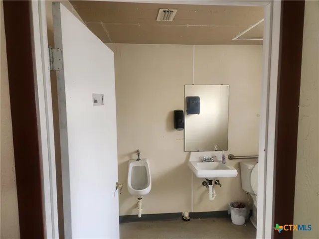 a bathroom with a sink mirror and toilet