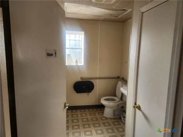 a bathroom with a toilet and a window