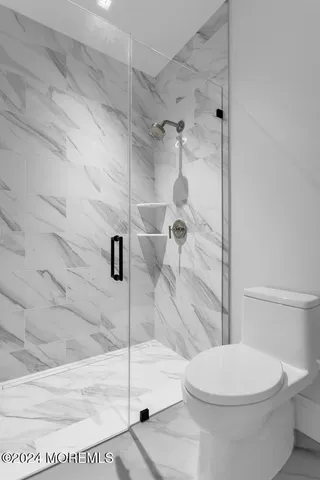 a white toilet sitting next to a bath tub and shower