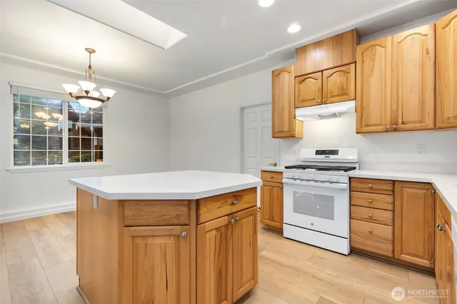 a kitchen with stainless steel appliances granite countertop a sink stove and cabinets