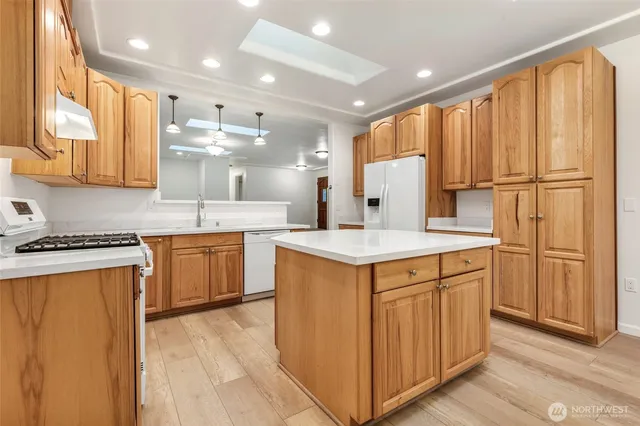 a kitchen with stainless steel appliances granite countertop a sink a stove and a refrigerator