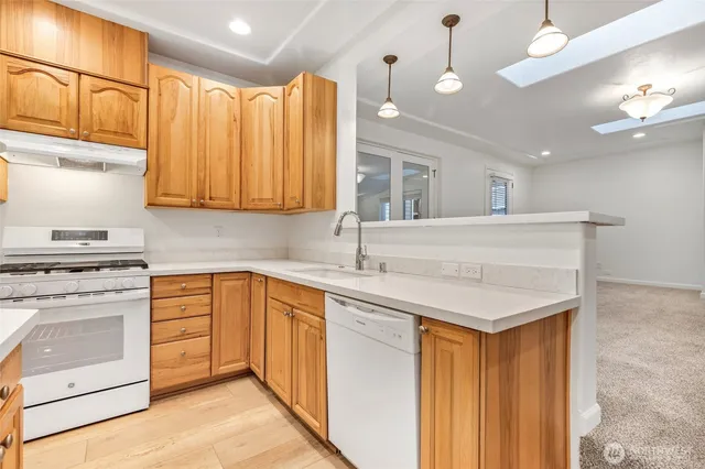 a kitchen with kitchen island granite countertop a sink and a refrigerator