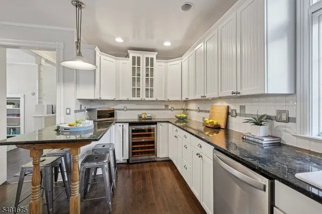 a kitchen with kitchen island granite countertop a sink a counter space appliances and cabinets