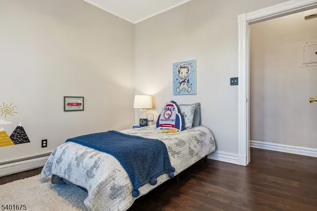 a bedroom with a bed and a lamp on the dresser