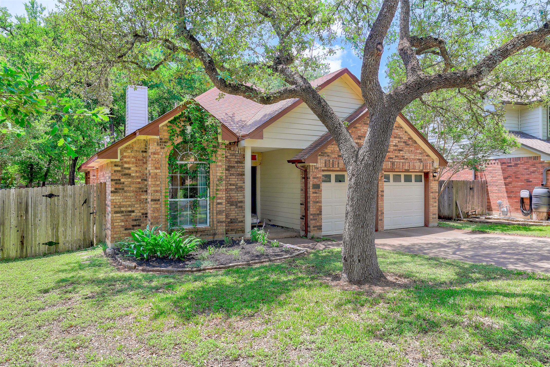 5907 Shanghai Pierce Road Austin, TX 78749 - Photo 3 of 29 View of front facade featuring concrete driveway, a garage, brick siding, and a chimney