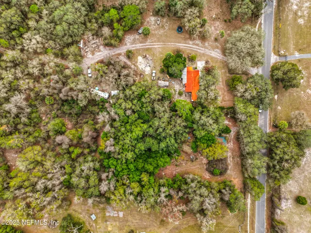 a backyard of a house with a yard and large trees