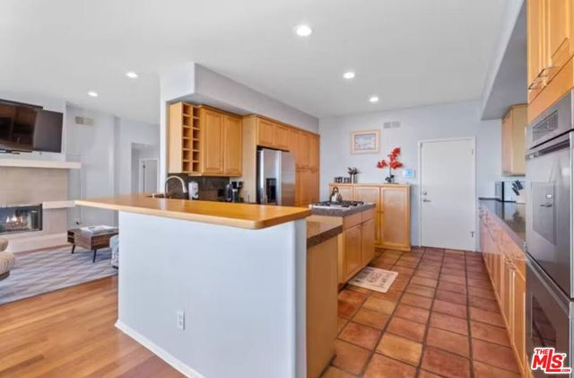 a kitchen with stainless steel appliances granite countertop a stove a refrigerator and a sink