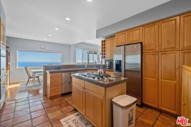 a kitchen with stainless steel appliances granite countertop a stove a sink and a refrigerator