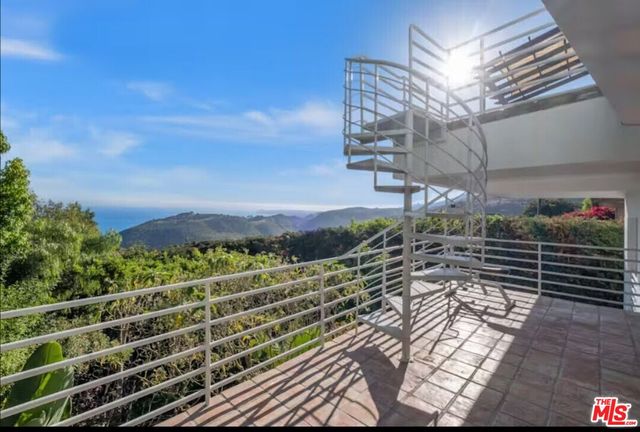 a view of balcony with wooden floor outdoor seating and entryway