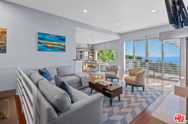 a view of a dining room with furniture a chandelier and wooden floor
