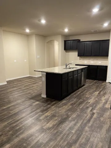 a large kitchen with stainless steel appliances granite countertop a sink and cabinets