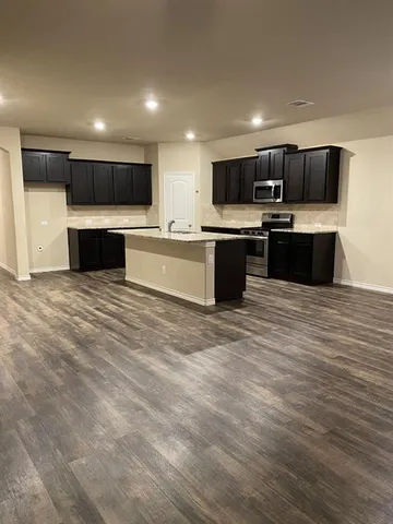 a large kitchen with stainless steel appliances kitchen island a large counter top stainless steel appliances and cabinets