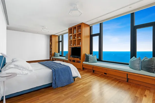 a bedroom with a bed and two large window